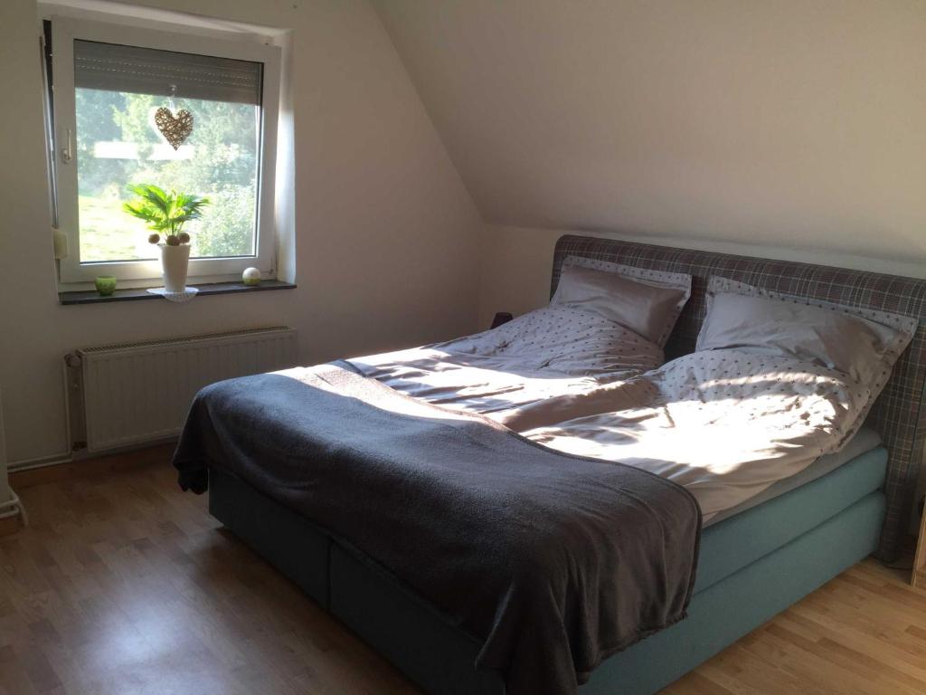 a bed sitting in a bedroom with a window at Ferienhaus Karin in Erfde