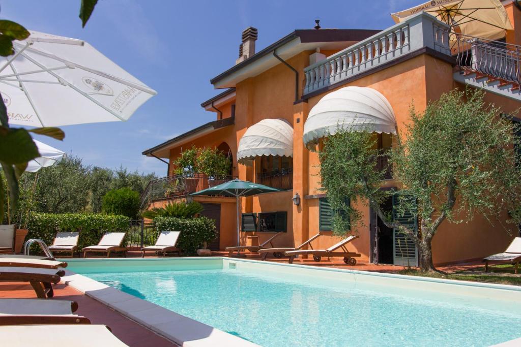 a house with a swimming pool in front of a building at Le Quattro Stagioni in Massa