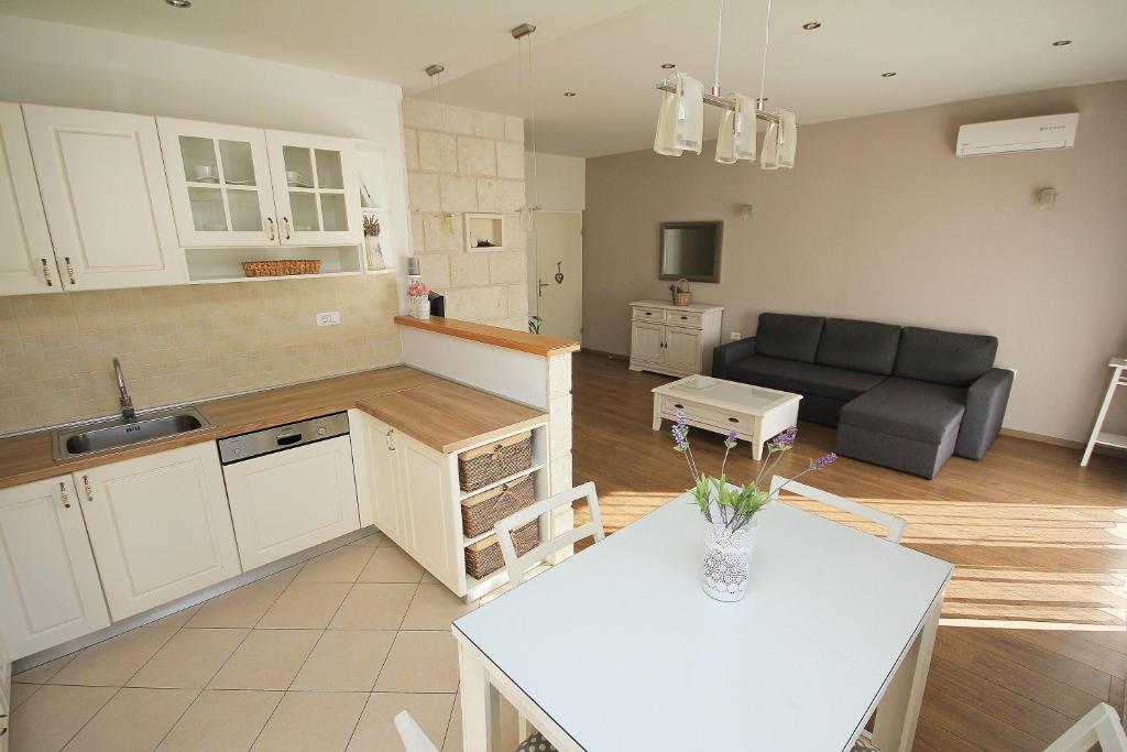 a kitchen and living room with a couch and a table at Apartmani Šulenta in Tučepi