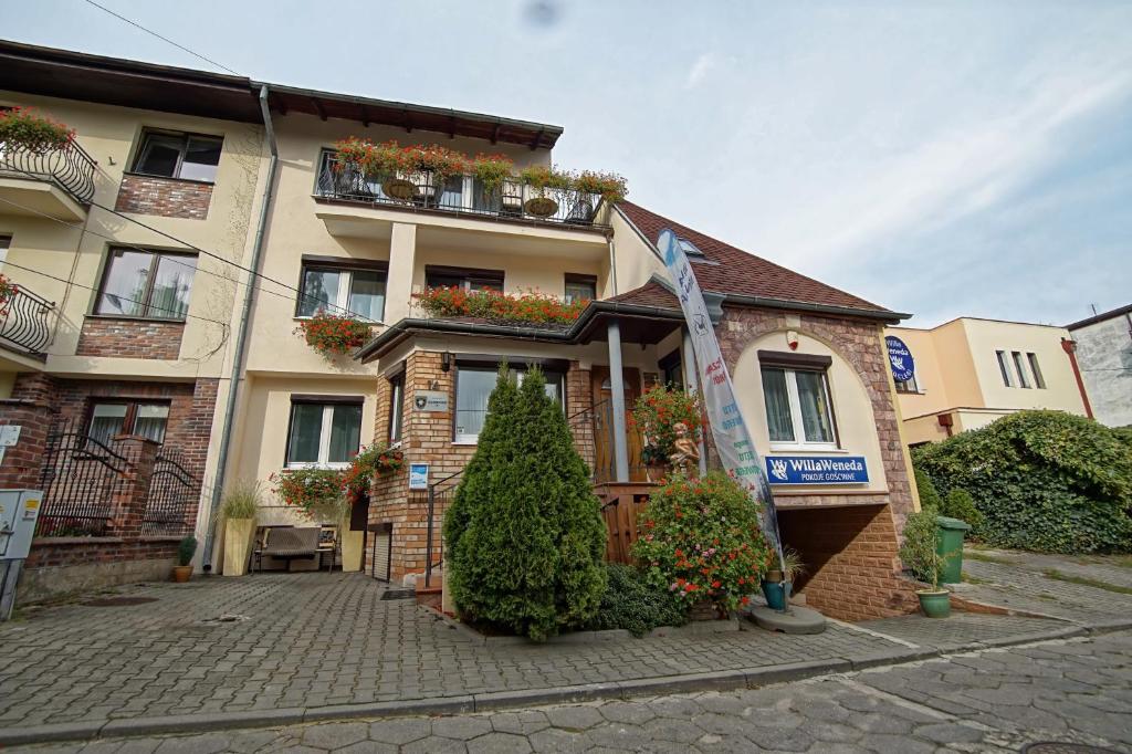 un bâtiment avec des fleurs devant lui dans l'établissement Willa Weneda, à Gdynia