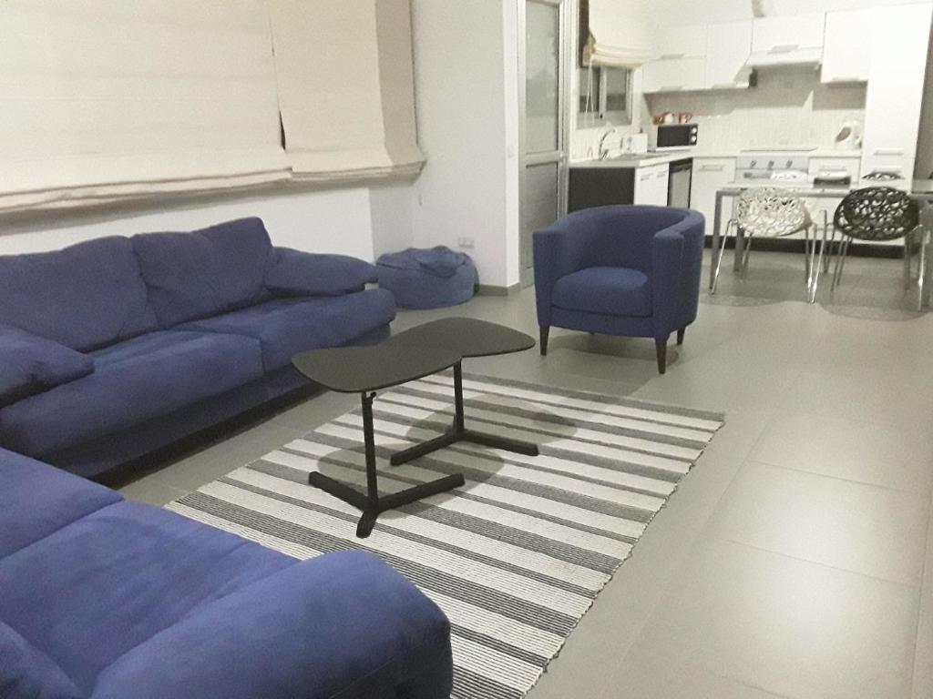 uma sala de estar com um sofá azul e duas cadeiras azuis em Julia's Residence em Nicósia