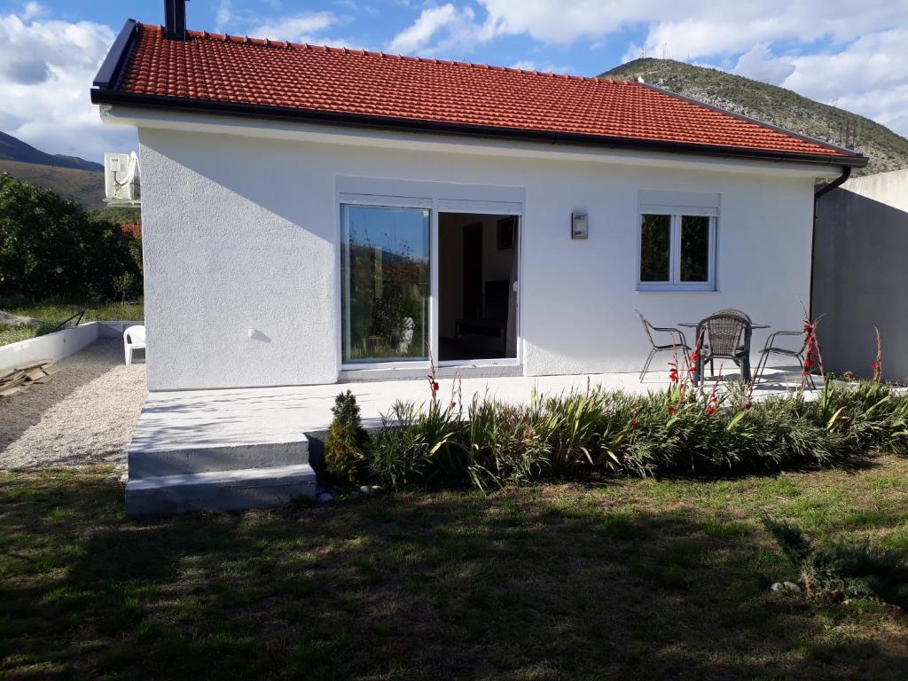 een klein wit huis met een rood dak bij Little Mostar house in Mostar