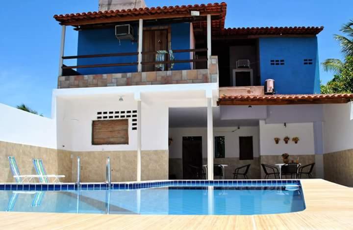 a house with a swimming pool in front of a house at Pousada Espaço Litoral in Baixio