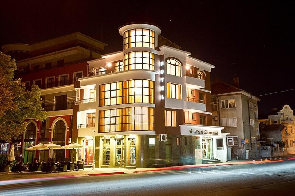 - un grand bâtiment éclairé la nuit dans l'établissement Hotel Diamond, à Kazanlak