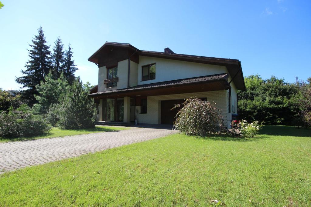 a house with a driveway and a grass yard at Villa EverGreen near the city center with private garden, hot tub, garage parking, patio in Vilnius
