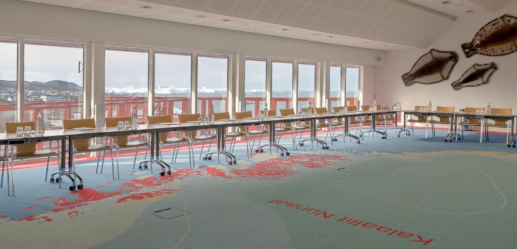 a room with tables and chairs with a world on the floor at Hotel Arctic in Ilulissat