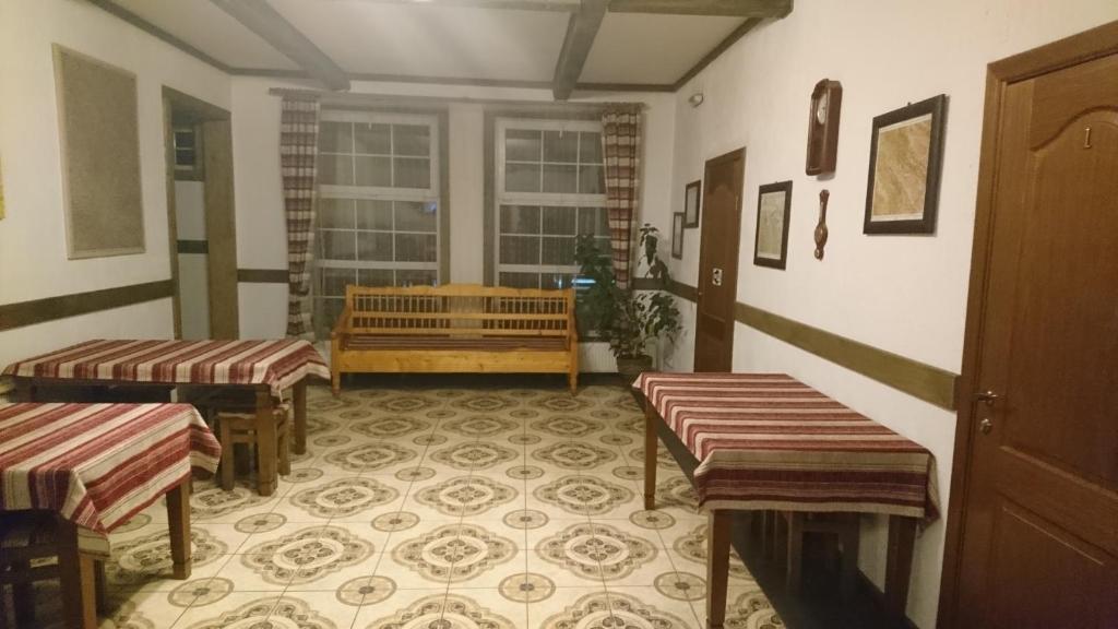 タターリウにあるMaghura Gostinnii Dvirのテーブル2台とベンチ付きの部屋