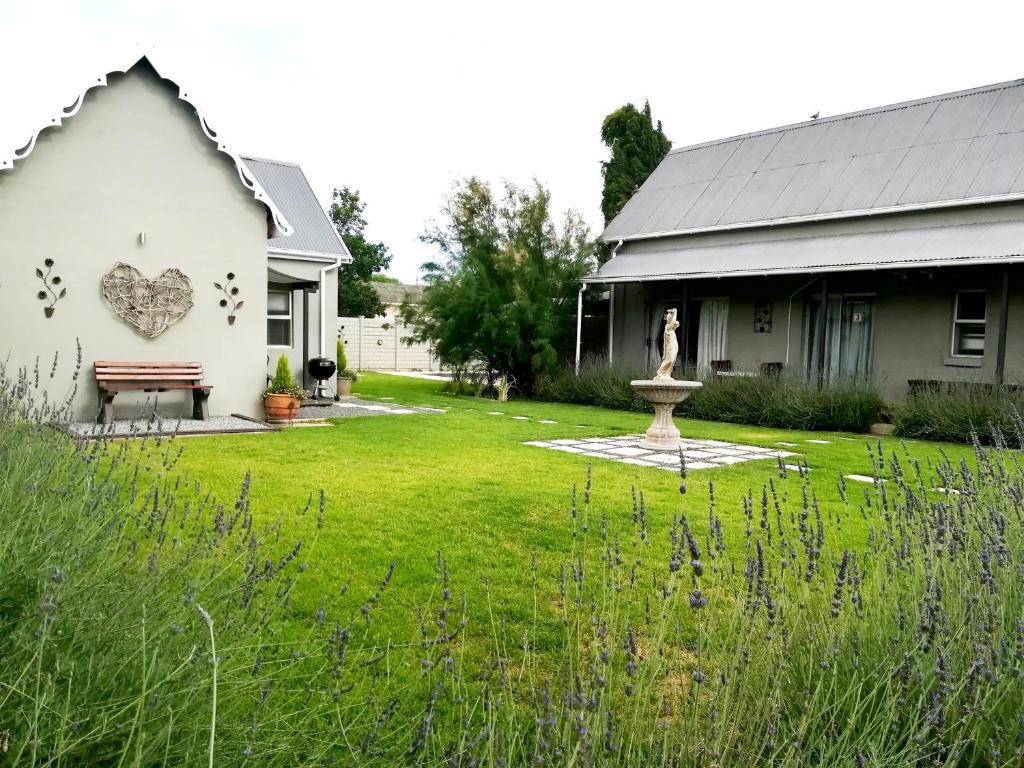 a white house with a statue in the yard at Tranquil House B&B @ 1 College Ave in Queenstown