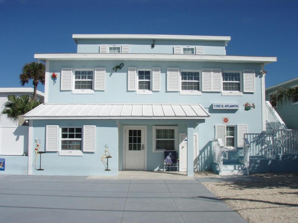 Casa azul y blanca con porche en Paradise In New Smyrna Beach Florida, en New Smyrna Beach