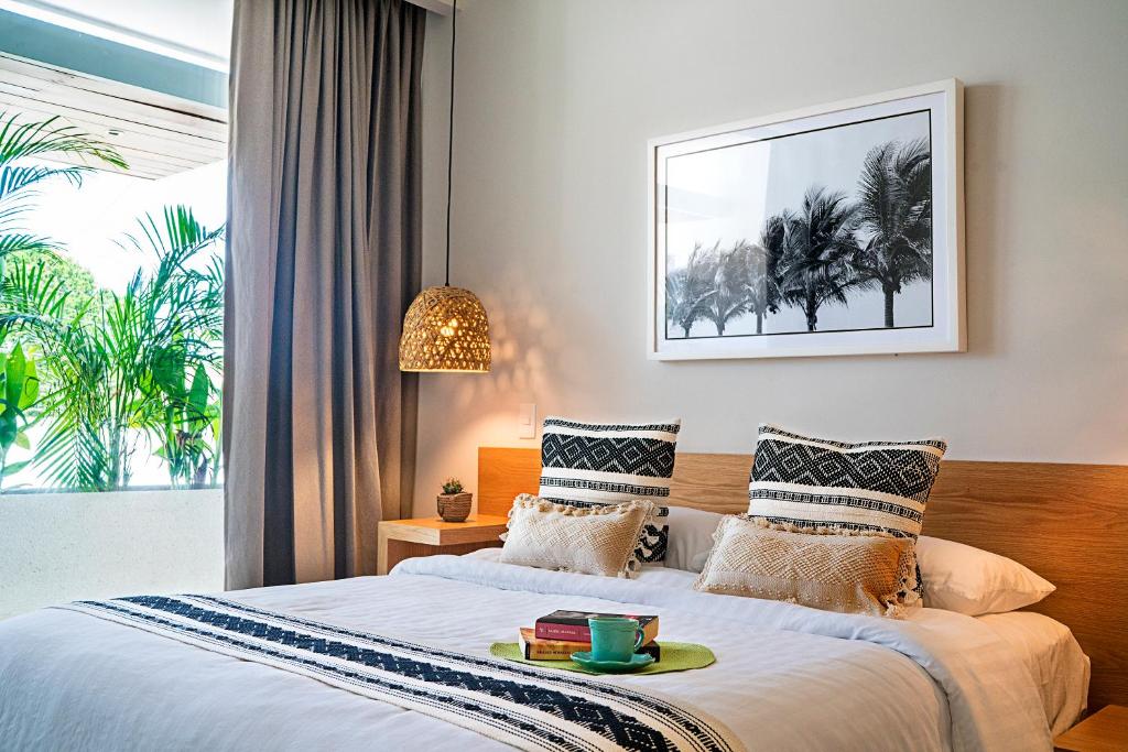 Un dormitorio con una cama con una bandeja de libros. en Arrecife Studios I Prime Location Steps to the Beach en Playa del Carmen