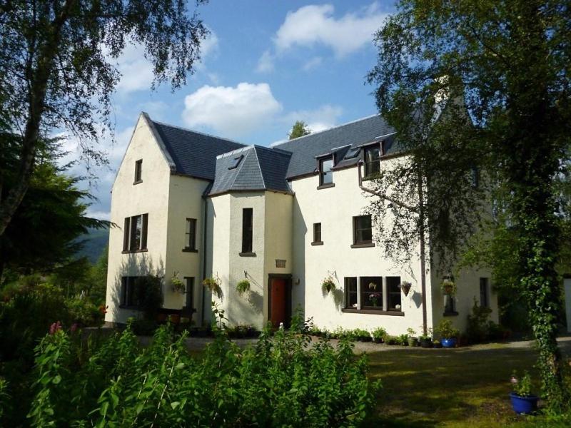 une grande maison blanche avec un toit noir dans l'établissement Kettle House B&B, à Fort Augustus