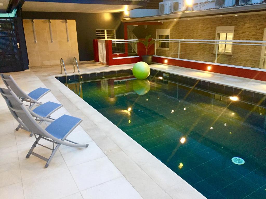 - une piscine avec 2 chaises et un ballon à l'eau dans l'établissement L'Eskale Guyane, à Montjoly