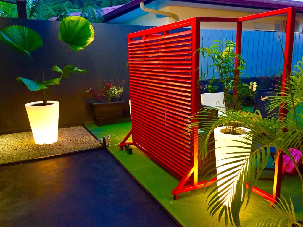 um quarto com uma porta vermelha e algumas plantas em L'Eskale Guyane em Montjoly
