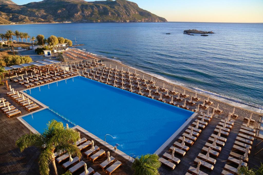 an aerial view of a resort with a pool and chairs at Alimounda Mare Hotel in Karpathos