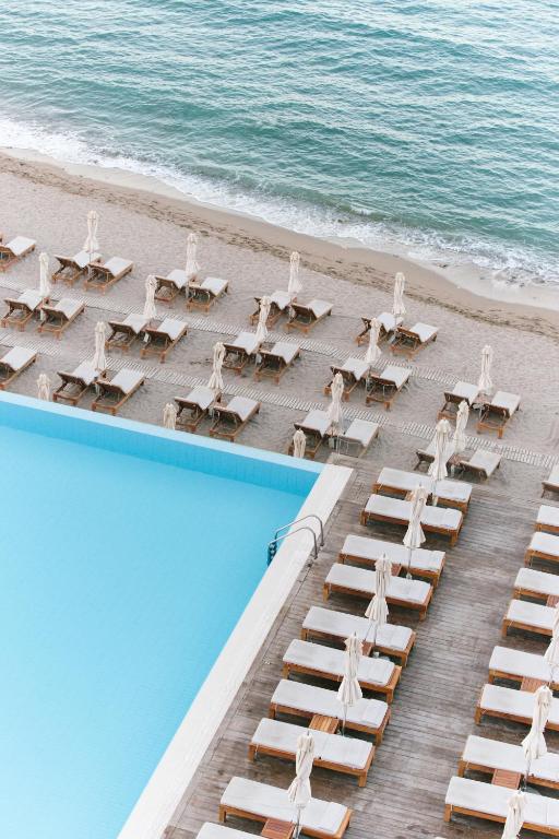 an overhead view of a beach with chairs and a pool at Alimounda Mare Hotel in Karpathos