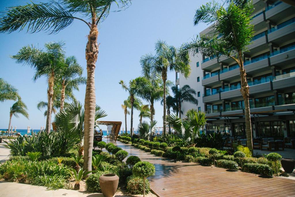 a resort walkway with palm trees and a building at Alimounda Mare Hotel in Karpathos