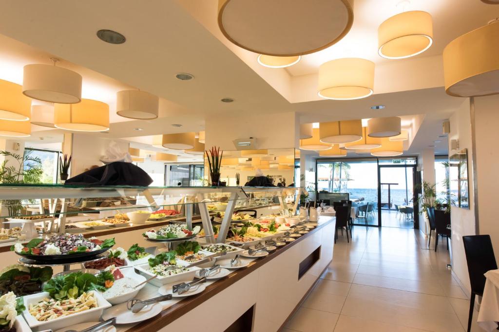 a buffet line in a restaurant with a lot of food at Alimounda Mare Hotel in Karpathos