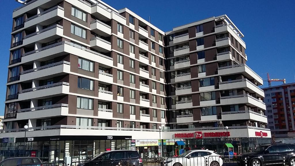 a large building with cars parked in front of it at Apartments Mladost 1A in Sofia