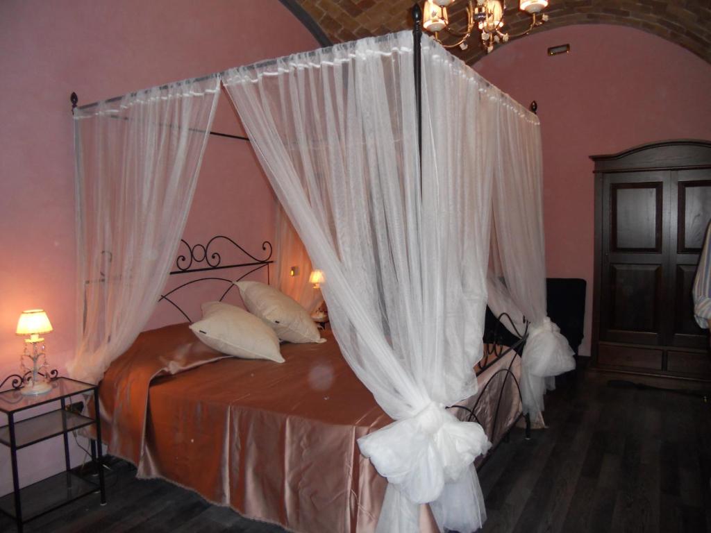 テルモリにあるB&B Vescovo Pitirroのベッドルーム(白いカーテン付きの天蓋付きベッド1台付)