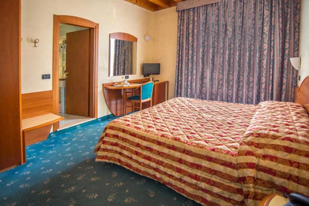 a hotel room with a bed and a desk at Hotel Brennero in Bassano del Grappa
