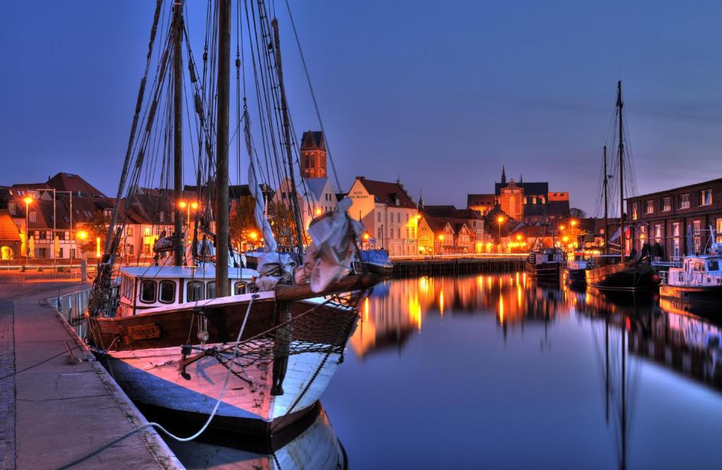 a boat is docked in a harbor at night at Hotel New Orleans in Wismar