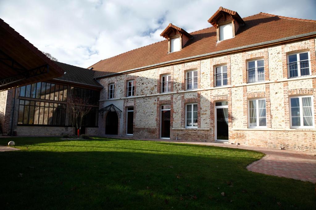 a large brick building with a grass yard at Gîte de la Crayère in Gionges