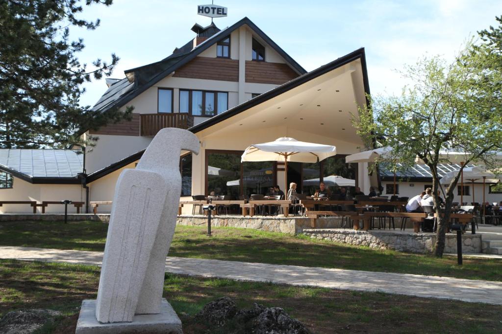 a building with a statue in front of it at Hotel Trebjesa in Nikšić