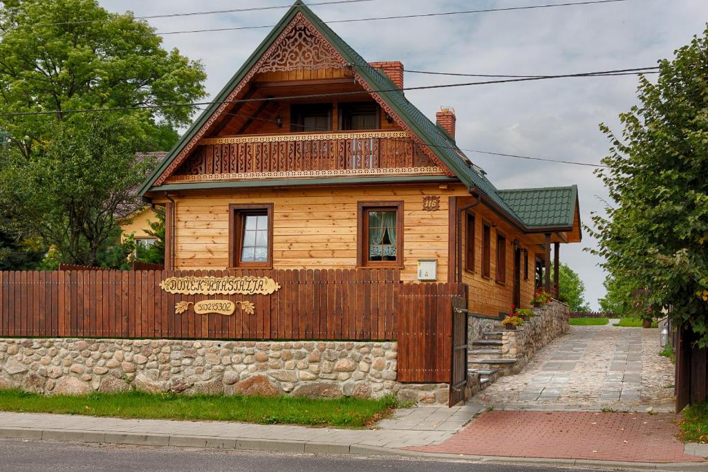 uma pequena casa de madeira com uma cerca de madeira em Aleksandrówka - Domek Anastazja em Trześcianka