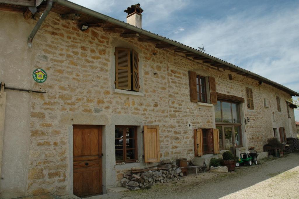 un antiguo edificio de ladrillo con puerta y ventanas en Le Bellaton, en Ambronay