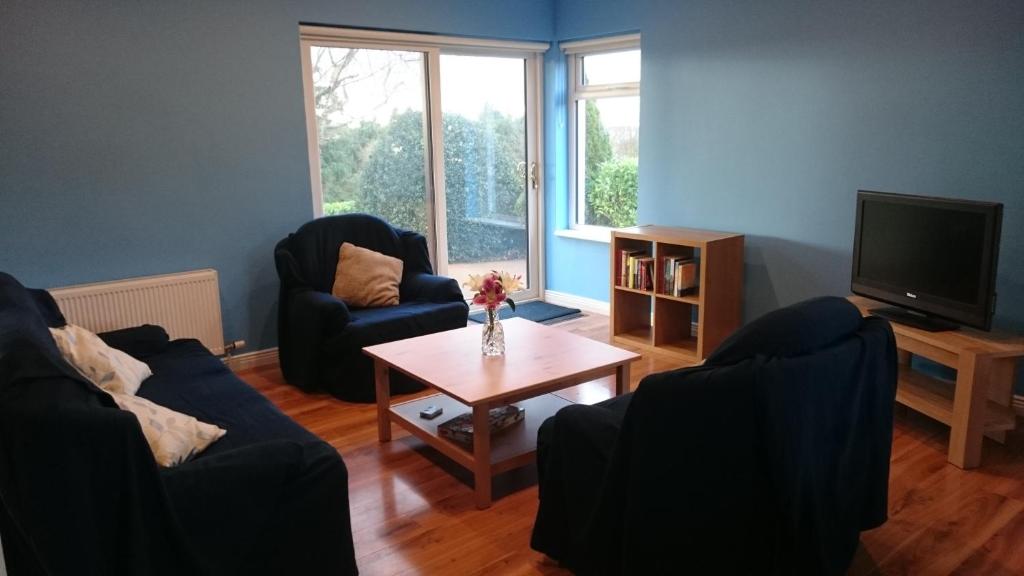 a living room with two chairs and a coffee table at Mick's Cottage in Loughrea