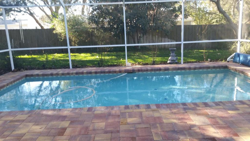 an empty swimming pool in front of a fence at Modern Pool Home in Spring Hill