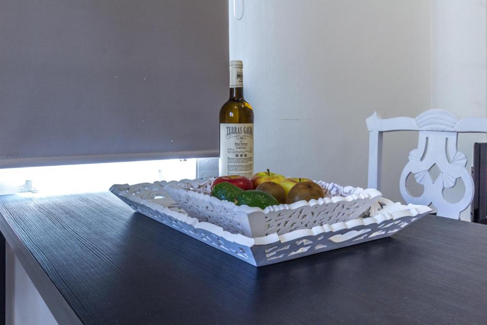 una botella de vino y una caja de fruta en una mesa en Ciudad Jardín Marina, en Las Palmas de Gran Canaria