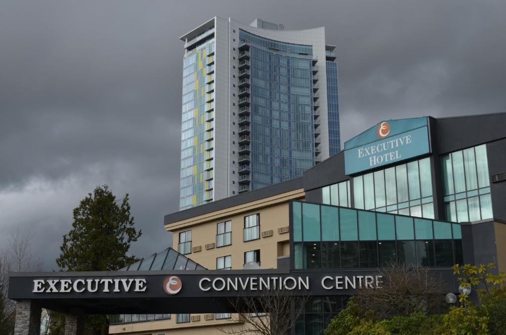un edificio con un cartello per un centro congressi di Executive Suites Hotel & Conference Center, Metro Vancouver a Burnaby
