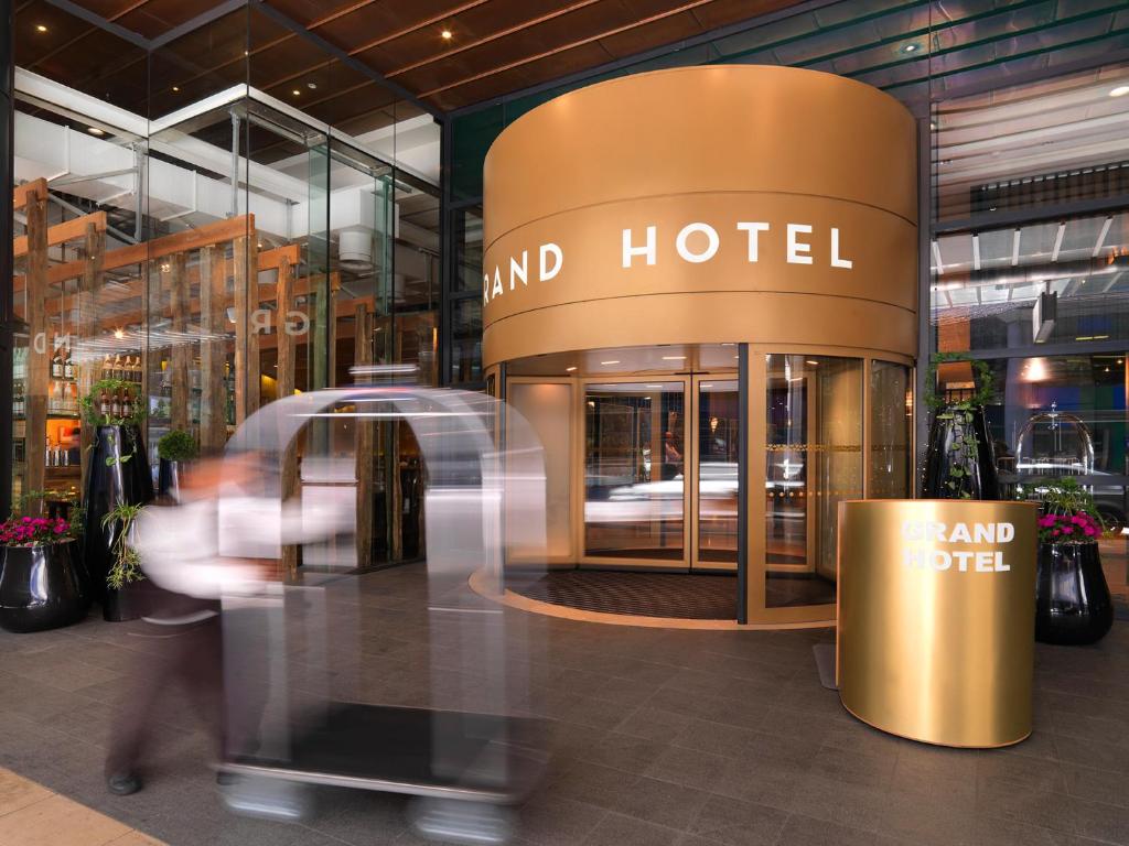 una persona caminando frente a un hotel en The Grand by SkyCity, en Auckland