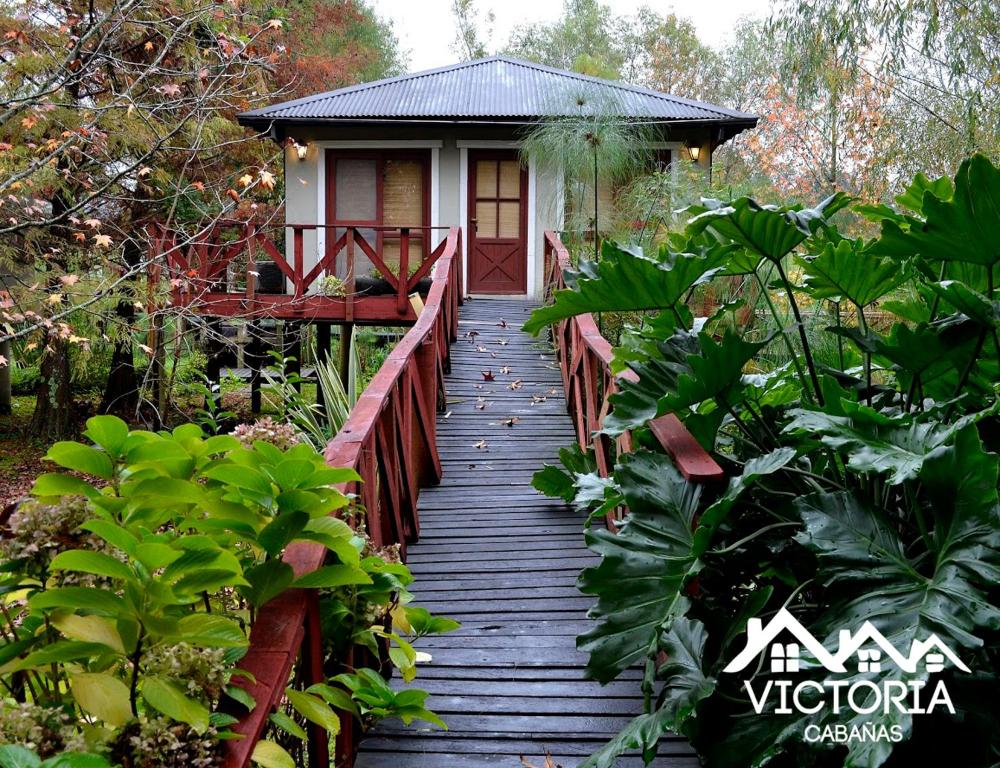 eine Holzbrücke, die zu einem kleinen Haus führt in der Unterkunft Victoria Cabañas in Tigre