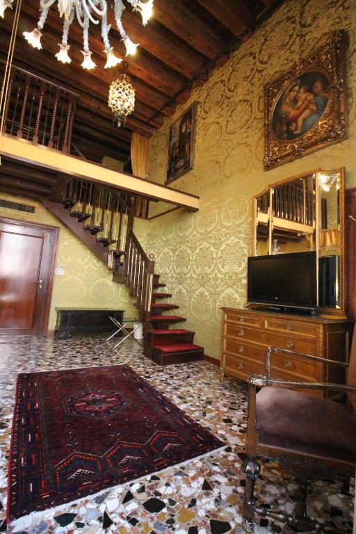 a living room with a staircase and a television at Hotel Palazzo Abadessa in Venice