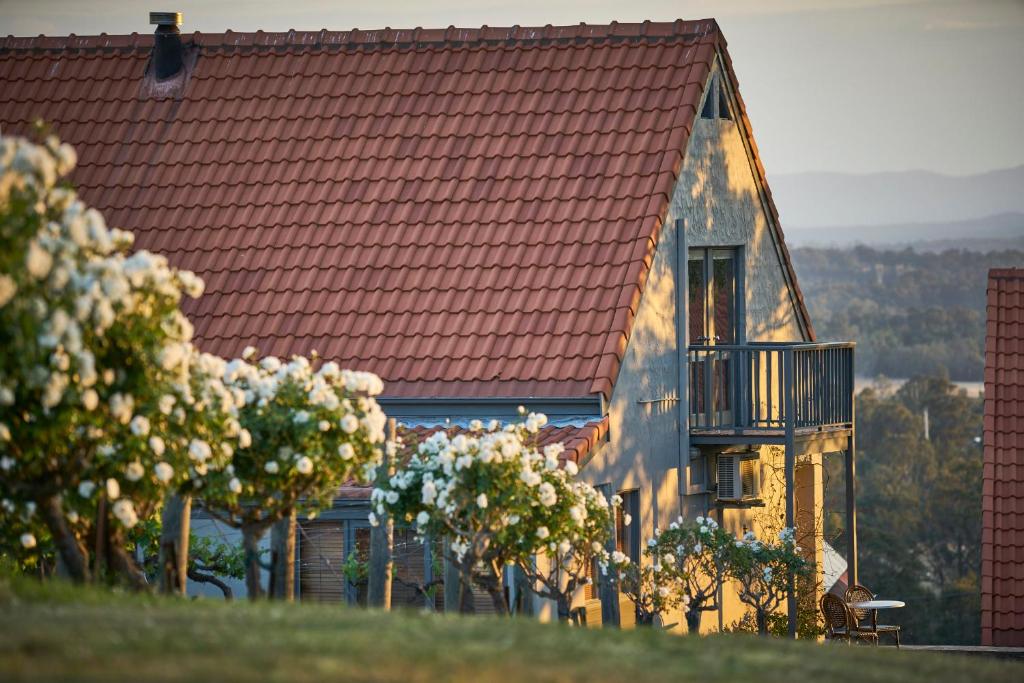 uma casa com um telhado vermelho e uma varanda em Wandin Valley Estate em Lovedale