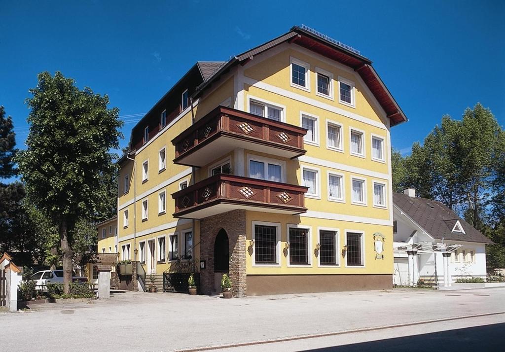 un gran edificio amarillo en una calle de la ciudad en Hotel Lindner, en Vöcklabruck