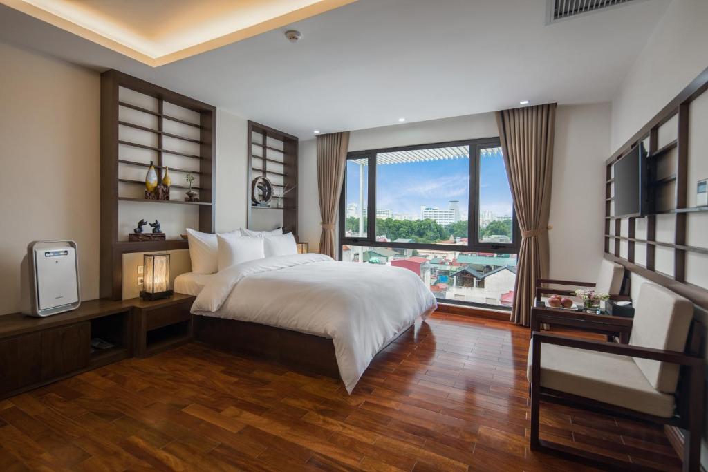 ein Schlafzimmer mit einem Bett und einem großen Fenster in der Unterkunft Brandi Fuji Hotel in Hanoi