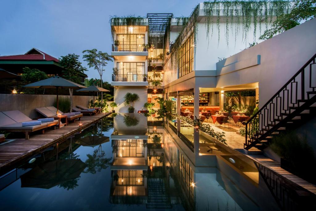 a hotel with a swimming pool in front of a building at Vihara The City of Temples in Siem Reap