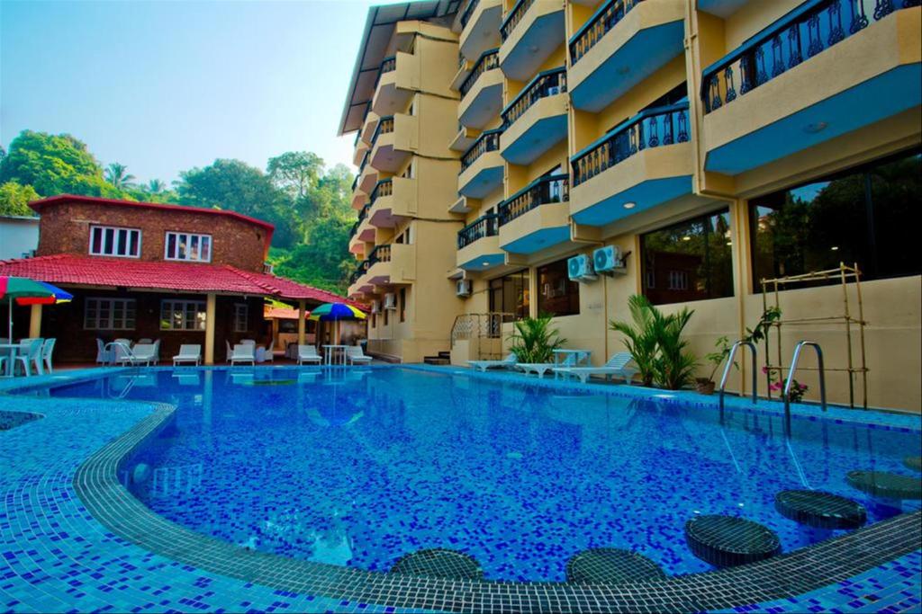 a large swimming pool in front of a building at Rendezvous Beach Resort Panjim in Dona Paula