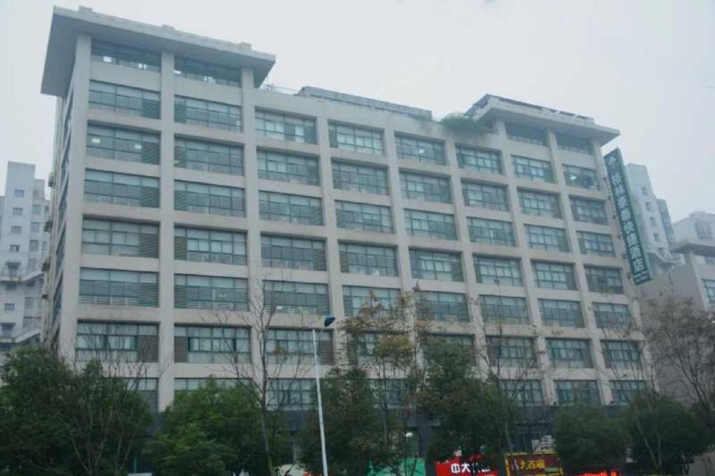 a large building with many windows in a city at GreenTree Inn Changzhou Xinbei District Taihu Road Wanda Plaza Dinosaur Park Express Hotel in Changzhou