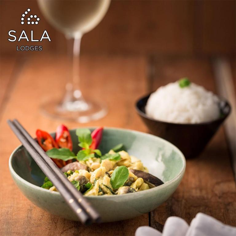 a bowl of food with rice and a glass of wine at Sala Lodges in Siem Reap