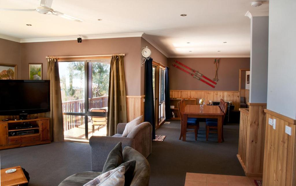ein Wohnzimmer mit einem Sofa, einem TV und einem Tisch in der Unterkunft Whistler in Bright