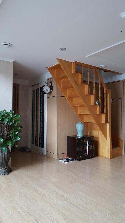 仁川にあるSky Homestayの家の中の木製の階段付きのリビングルーム