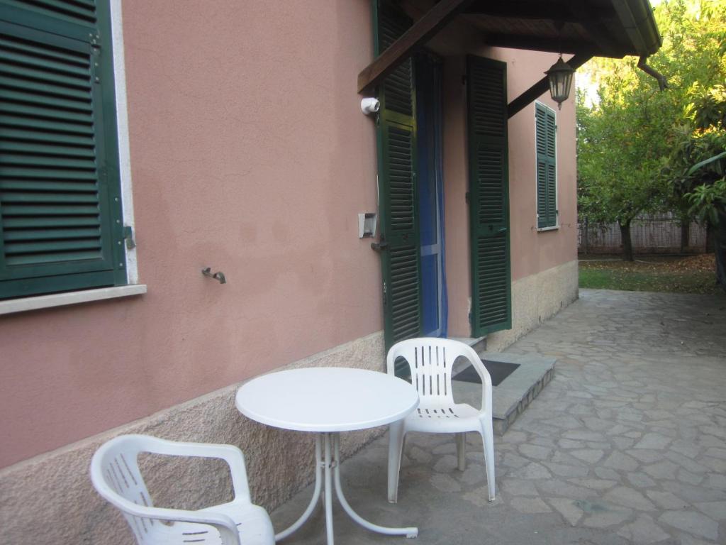 ラ・スペツィアにあるCa' di Boschetti Old Farm 2.0の白い椅子2脚と建物横のテーブル