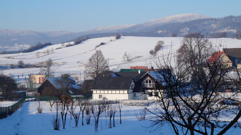 un pueblo en la nieve con una colina en Dom pod lawendowym polem, en Wolibórz