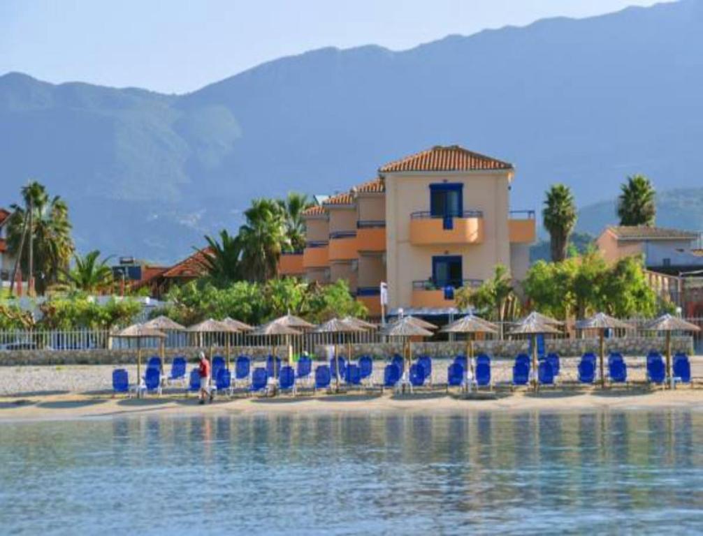 a group of blue chairs and umbrellas on a beach at Akroyiali Resort in Vasiliki