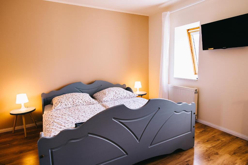 ルッケンヴァルデにあるAnnes Pensionのベッドルーム1室(ベッド1台、壁掛けテレビ付)