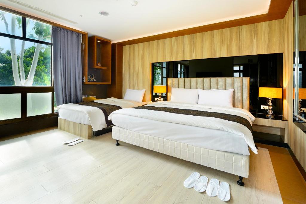 金沙鎮的住宿－金沙湖畔渡假會館，一间卧室设有两张床和大窗户